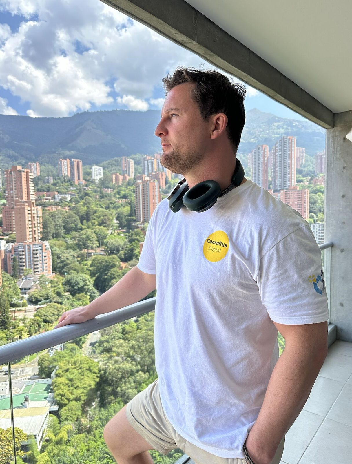 A team member working from a balcony abroad in a Consultus Digital shirt