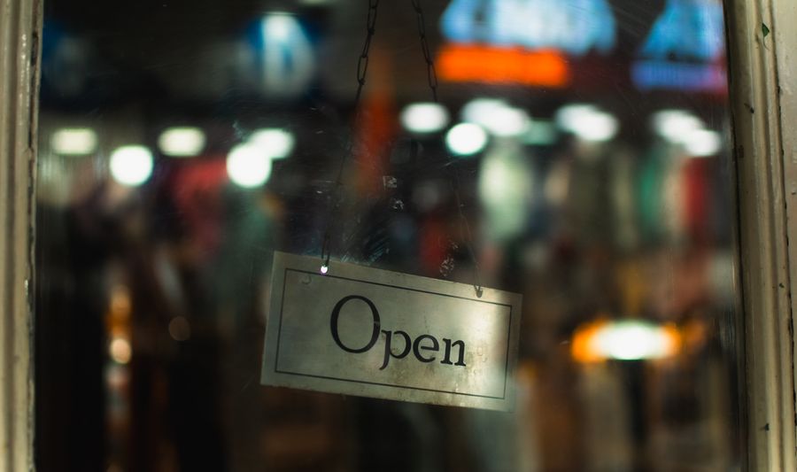 Open sign hanging in a shop window