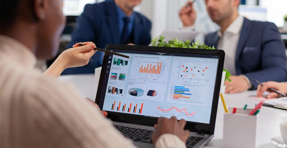 Colleagues reviewing a data dashboard on a laptop in a meeting