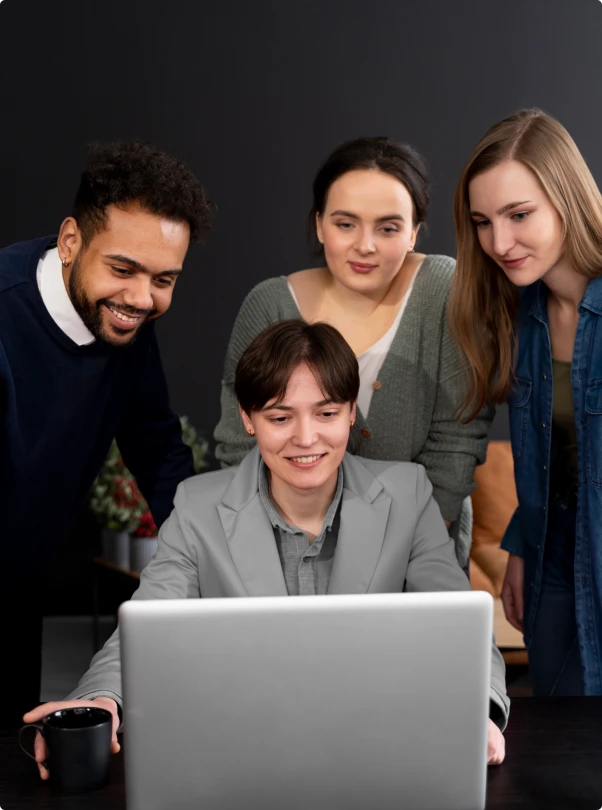 Four colleagues gathered around a laptop