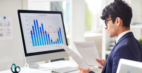 Analyst reviewing a bar chart on a desktop monitor