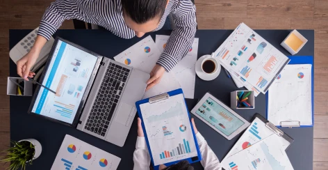 Overhead view of a team working over a desk covered in marketing charts