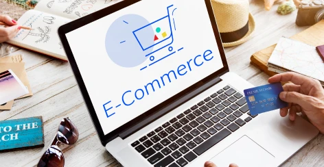 Laptop showing an e-commerce page while a shopper holds a payment card