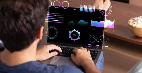 Person typing on a laptop with data charts overlaid on the screen