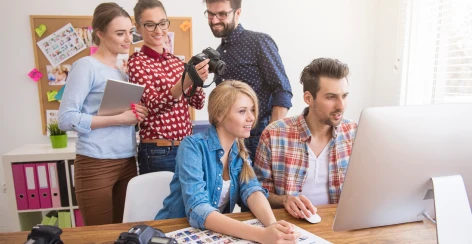 Creative team gathered around a desk reviewing a photo shoot