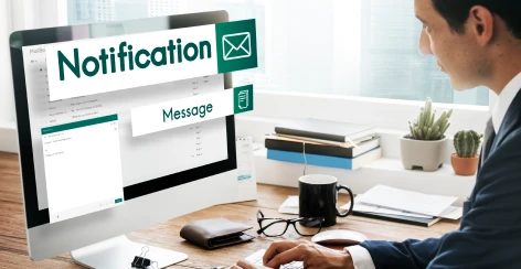 Email notification graphic beside a man working at a desktop computer