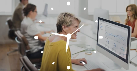 Woman working at a desktop computer behind a clock graphic