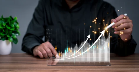 Rising revenue chart projected above a tablet