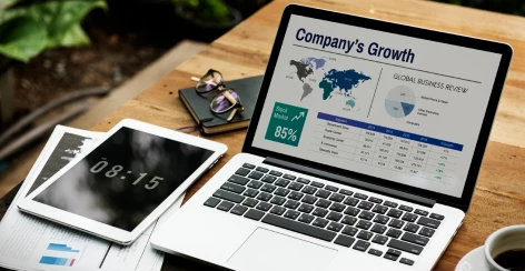 Laptop showing a company growth dashboard beside a tablet