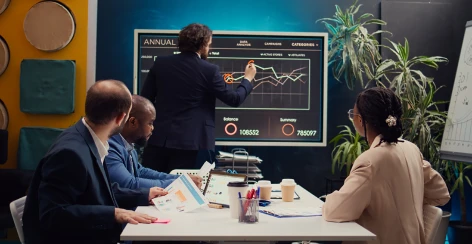 Team reviewing annual revenue charts on a wall screen