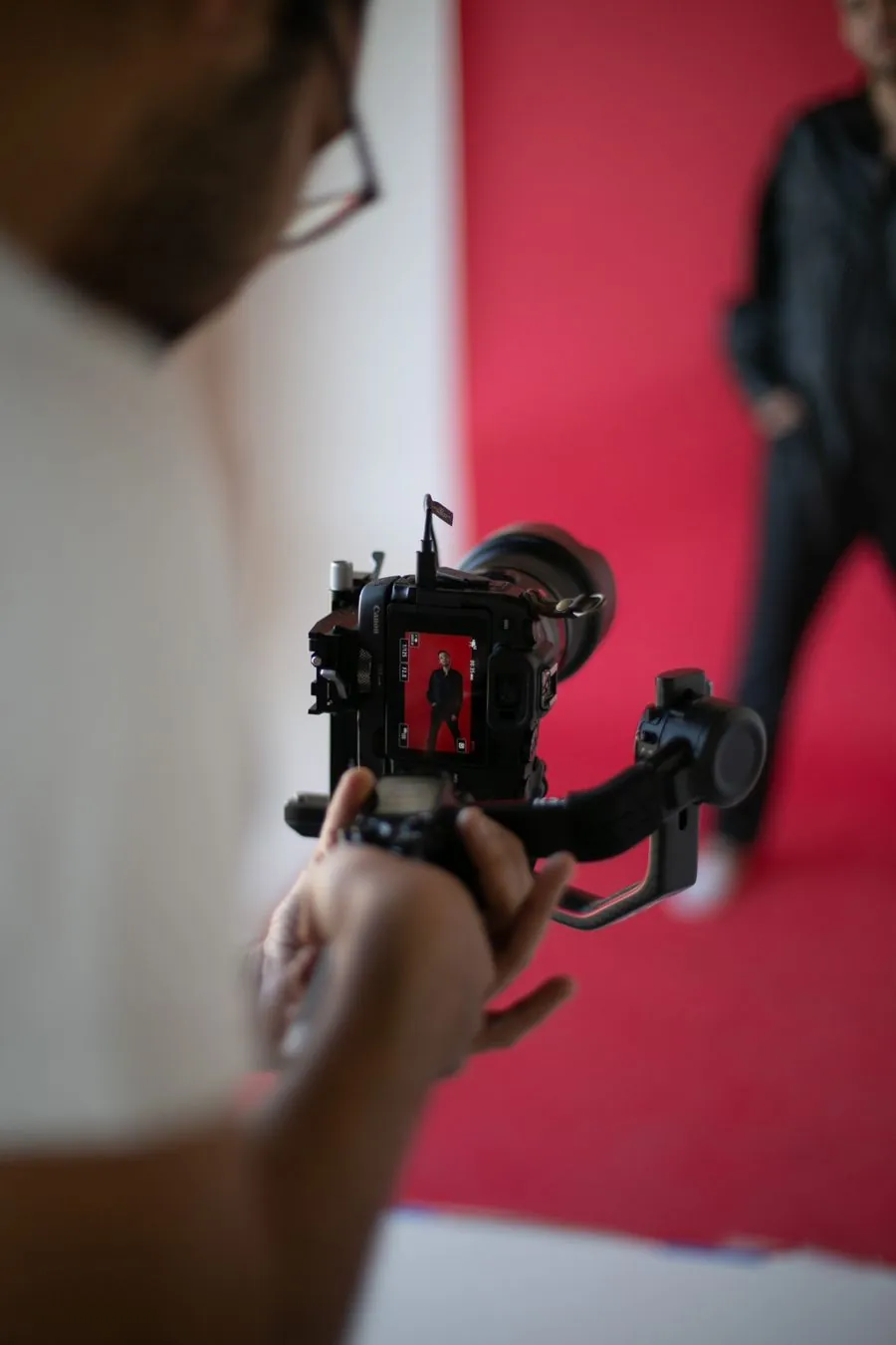 A photographer holding a gimbal camera during a studio photoshoot