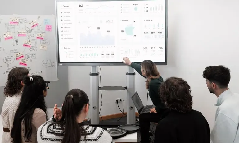 Team reviewing a campaign dashboard on a wall screen