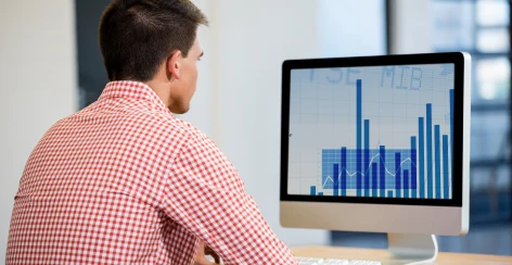 Man watching a bar chart on a desktop monitor