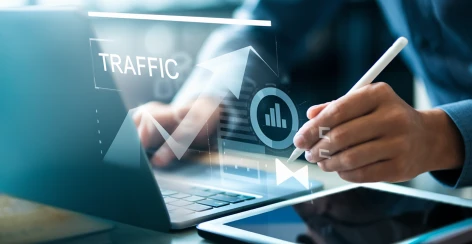 Hand with a stylus beside a traffic growth graphic