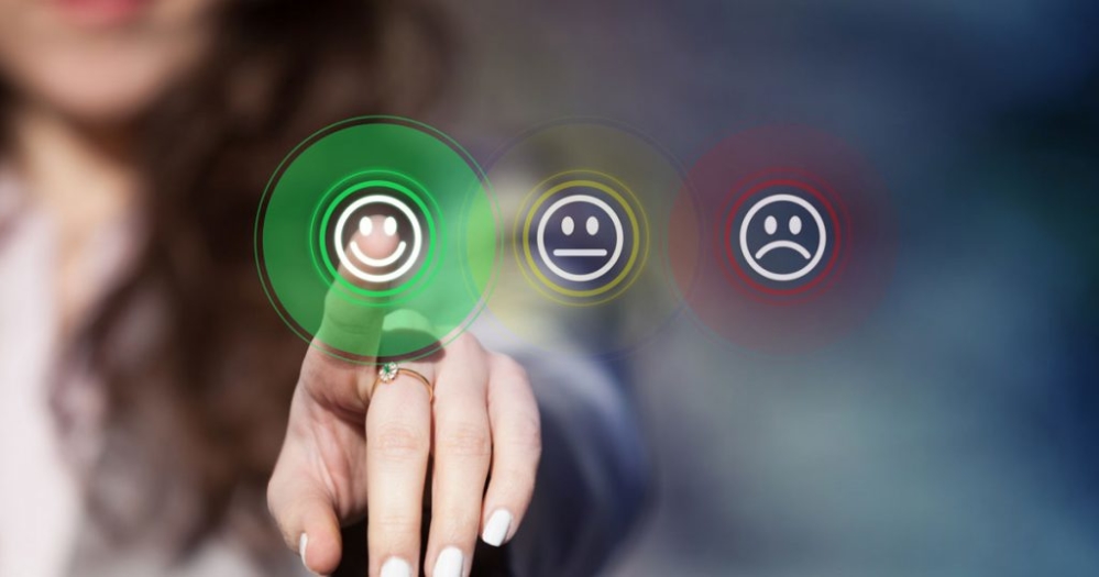 Woman pressing on customer experience ratings with fingertip