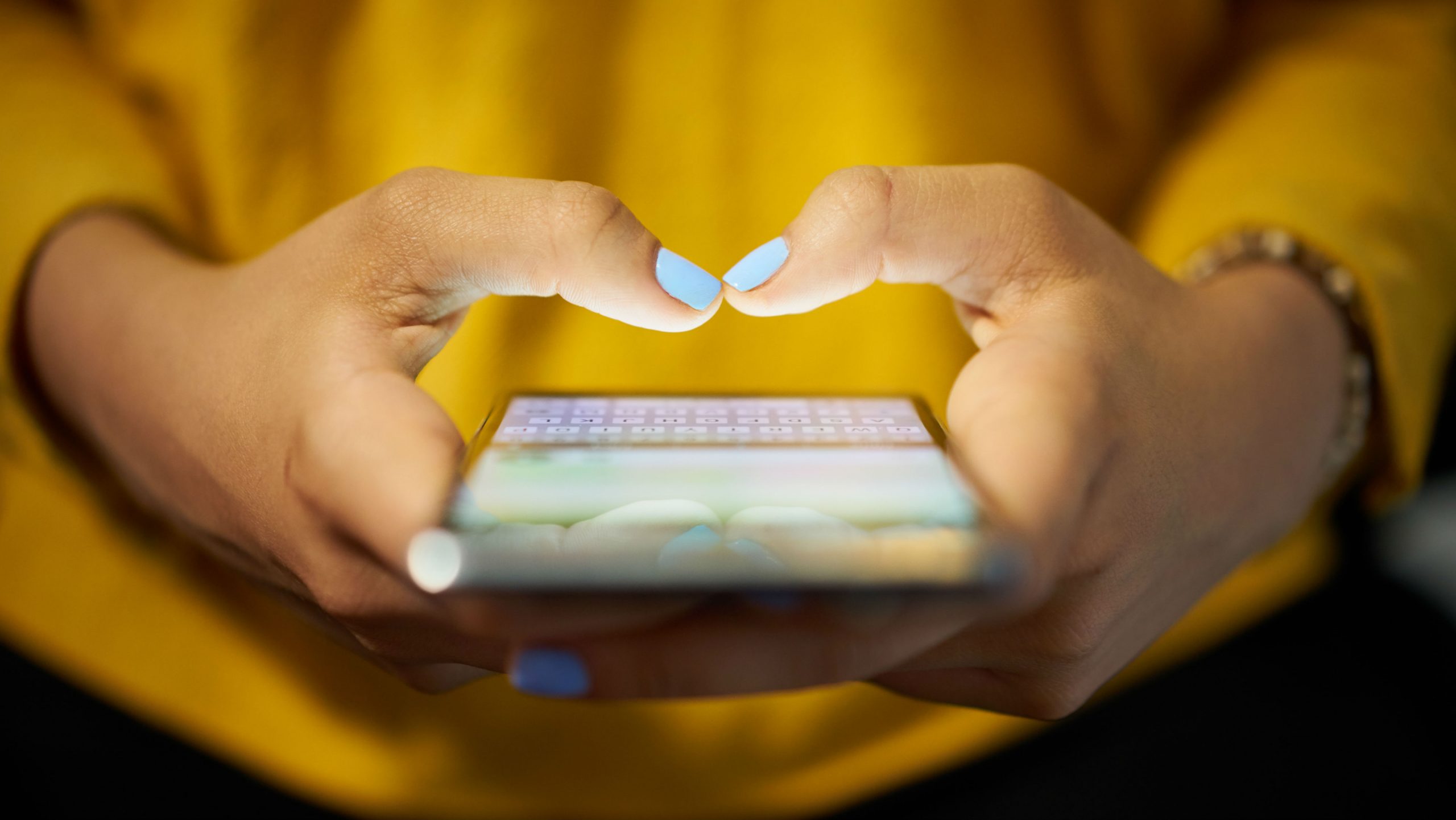 Woman in yellow shirt using mobile phone
