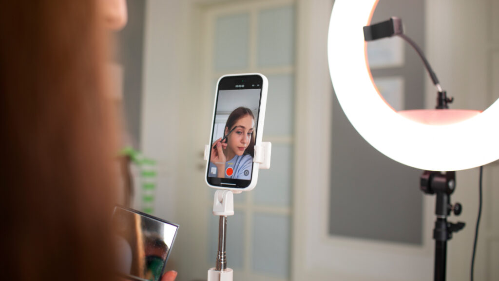 woman setting up ring light and mobile device to film - short-form video