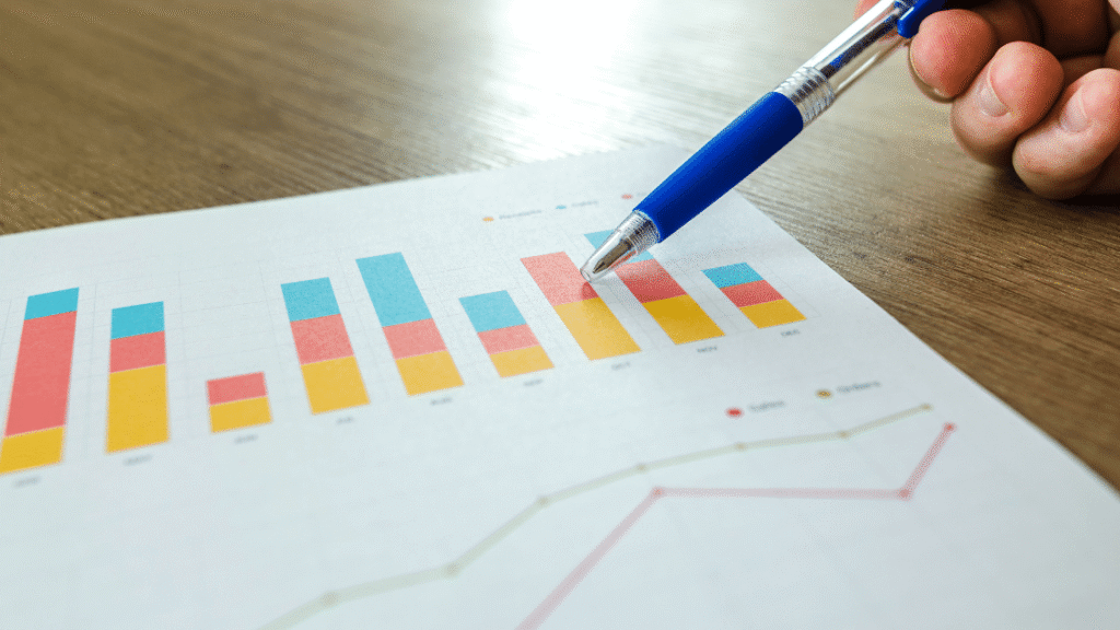 Hand with pen pointing at bar chart indicating success of growth marketing by Consultus Digital