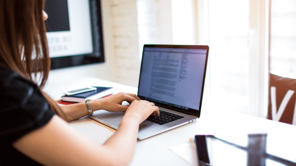 A woman writing content on her laptop, which helps with future-proofing her SEO strategy. 