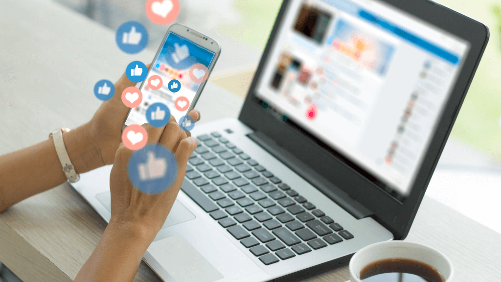 Customer using a phone with a Facebook Ad loaded and a laptop with a computer in the backdrop with Facebook loaded too