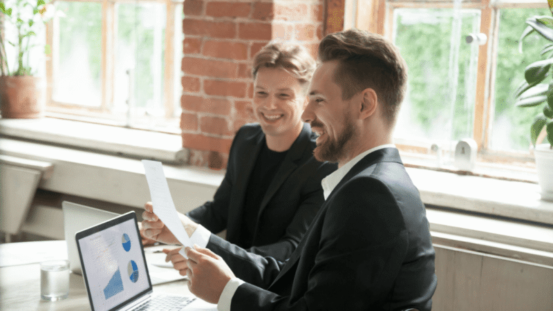 Two marketers reviewing a Toronto client CRO (Conversion rate optimization) audit and finding positive results