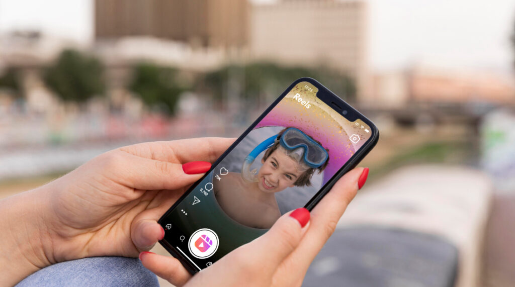 A digital marketer holding up a smartphone with instagram logo loading