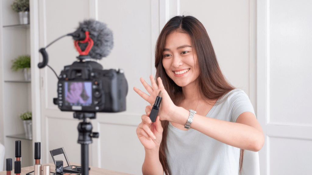A marketing influencer recording a short video of a lip stick related ad. 