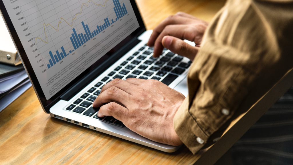 Marketer pointing at Macbook Pro screen showcasing value in increasing Google Ads CTR for digital marketing campaign,