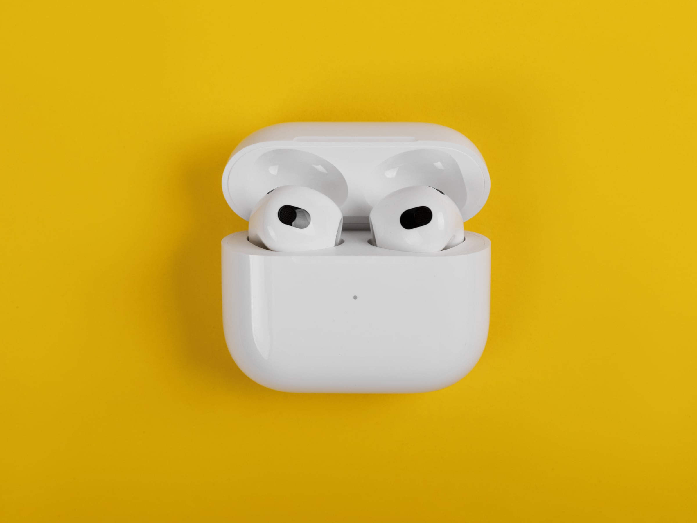 Apple AirPods on green background