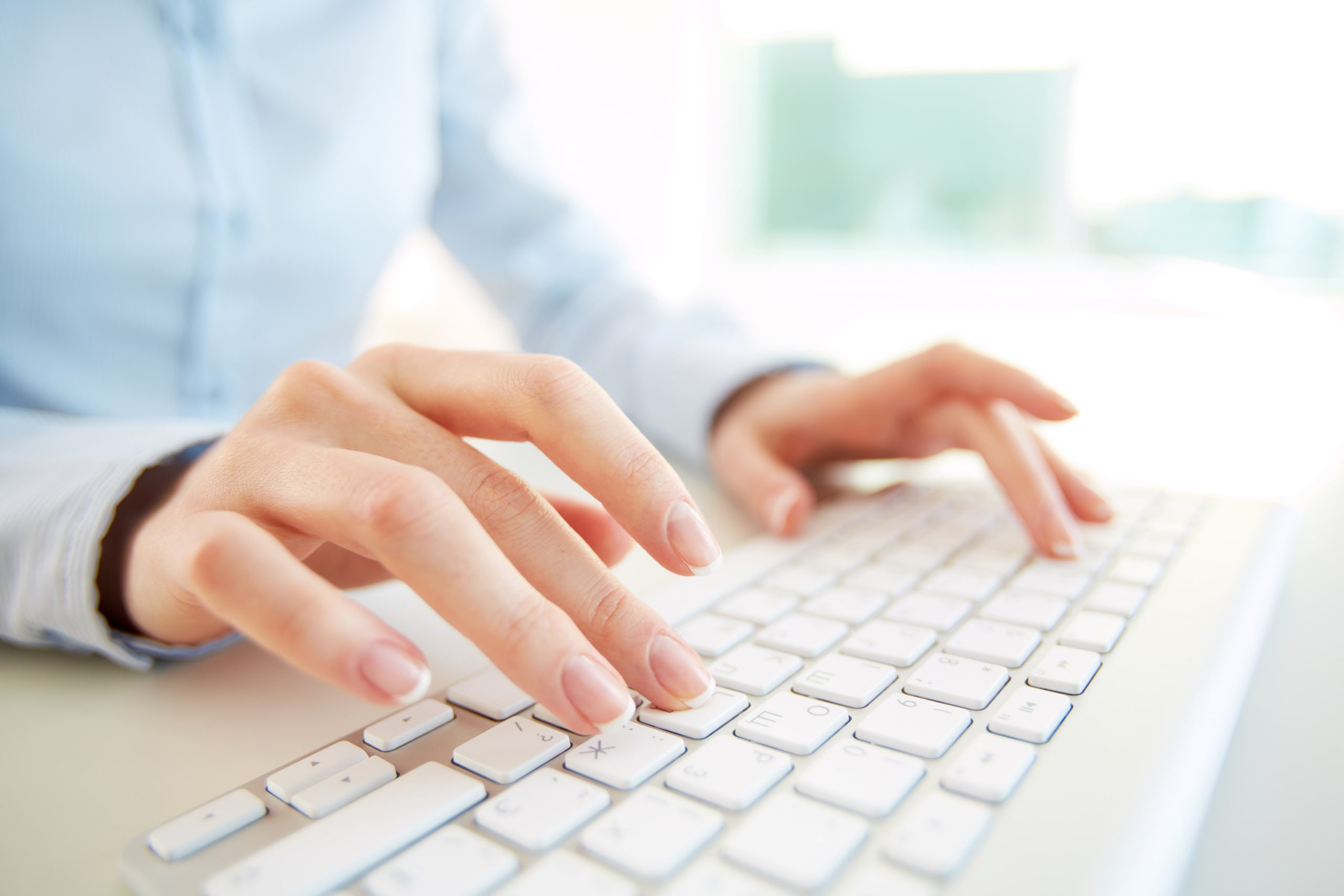 Close up of a woman typing on a computer
