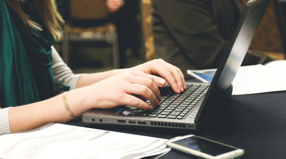 woman writing on a laptop computer