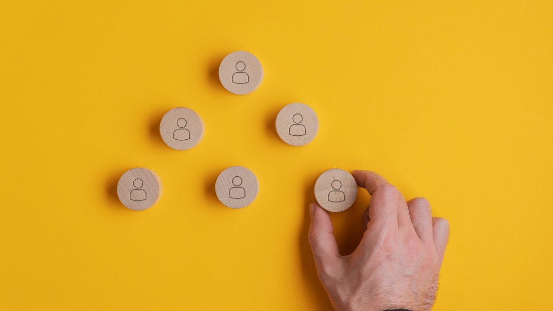 Person displaying wooden disks with people outlines on them to showcase crm for business