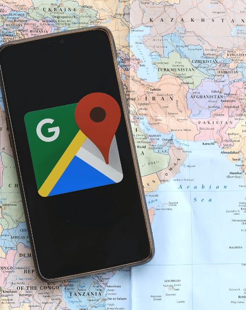 local seo: mobile device displaying google maps icon. Device is laid on a map of the world