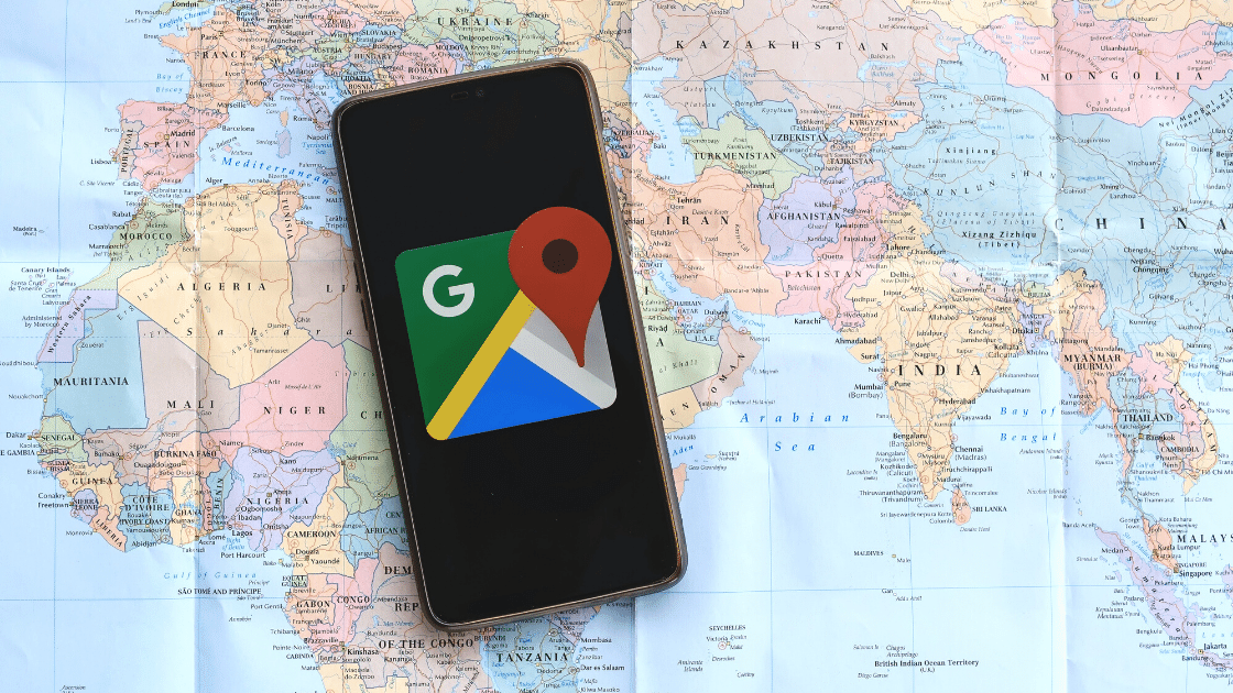 local seo: mobile device displaying google maps icon. Device is laid on a map of the world