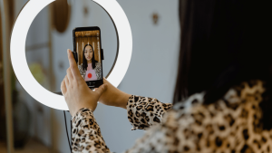 woman setting up ring light and mobile device to film - short-form video