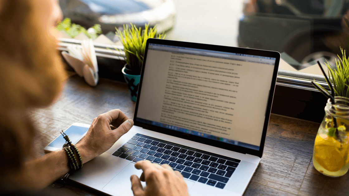 Digital marketer on Macbook Pro writing about 8 copywriting tips that help increase conversions