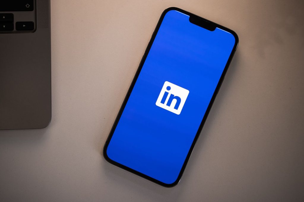 Smartphone with Linkedin image loading on screen prior to beginning to use Linkedin message ads