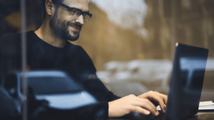 Digital marketer behind glass on his computer working on how to avoid SEO cloaking for a client.
